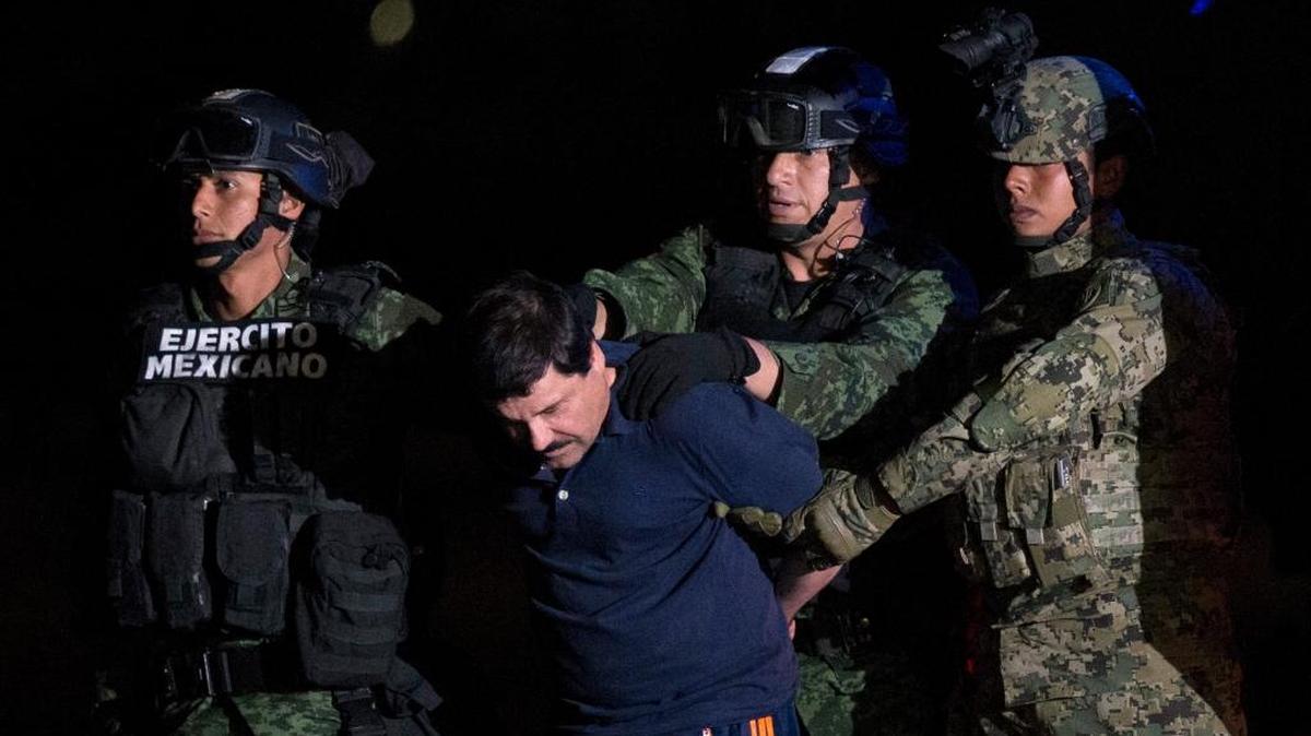 Mexican drug lord Joaquin "El Chapo" Guzman is escorted by army soldiers to a waiting helicopter, at a federal hangar in Mexico City.