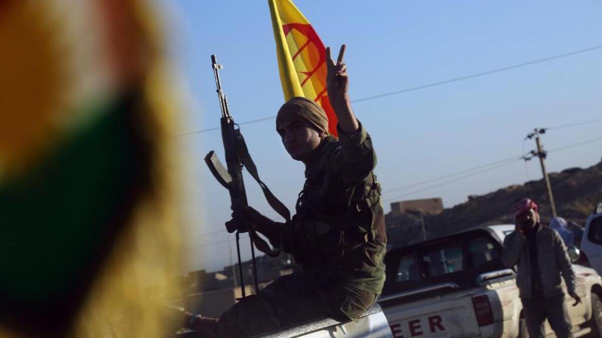 A fighter from the Kurdistan Workers Party, or PKK, which has been designated a terrorist group by the U.S. and Turkey, celebrates his group's role in the liberation of Sinjar, Iraq.