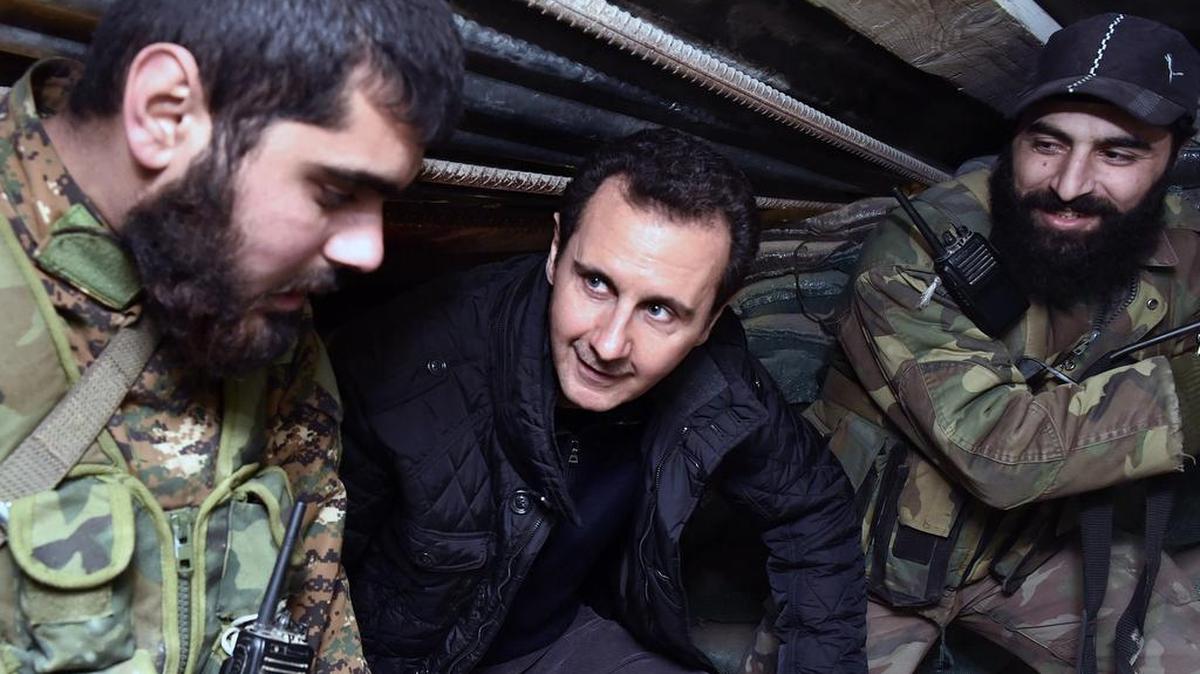 
In this Dec. 31, 2014, photo, released by the Syrian official news agency SANA, Syrian President Bashar Assad, center, speaks with Syrian troops during his visit to the front line in the eastern Damascus district of Jobar, Syria. The country has already been shattered by more than four years of civil war, and with no solution in sight some players on the ground and observers outside have concluded its fate will be to break up along sectarian or regional lines, in a best-case scenario, tenuously held together by a less centralized state. 
