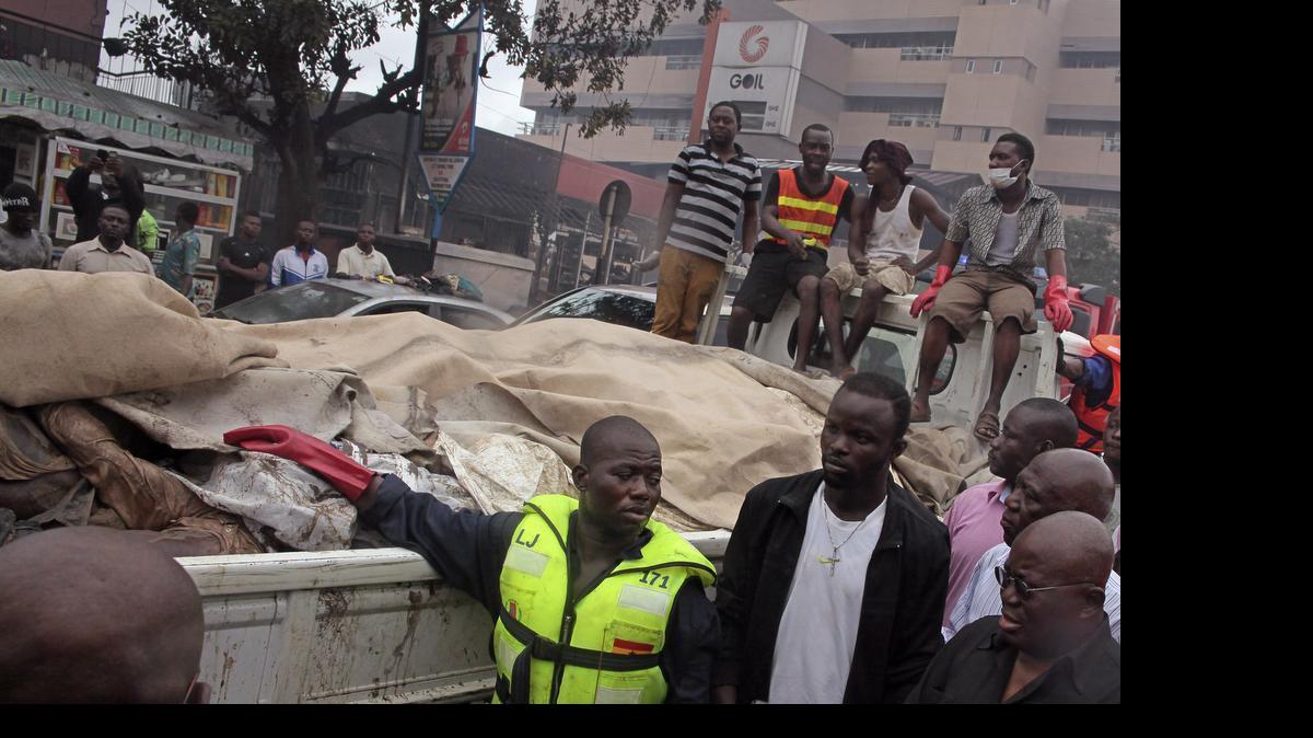 
The remains of people killed in a gas station explosion are loaded onto a truck in Accra, Ghana, Thursday, June 4, 2015. Flooding in Ghana's capital swept stored fuel into a nearby fire, setting off a huge explosion at a gas station that killed scores of people and set alight neighboring buildings, authorities said Thursday.
