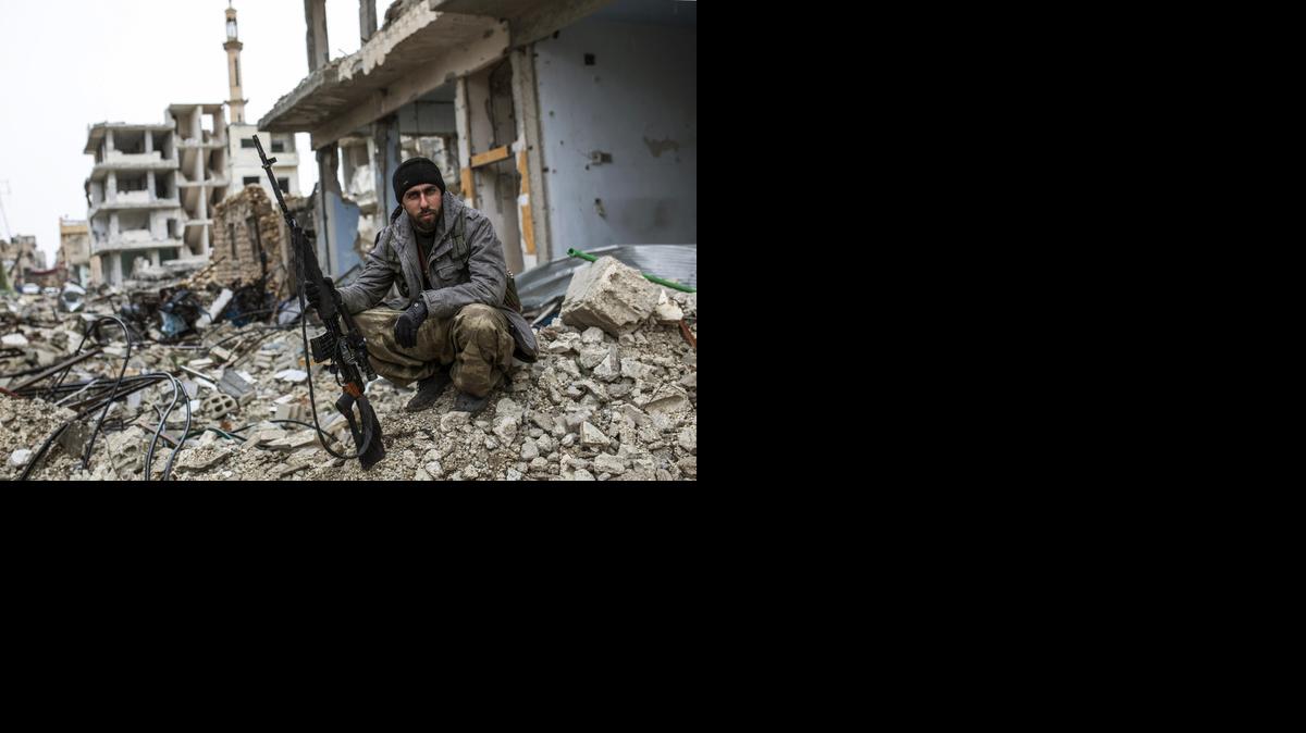 
In this picture taken Friday, Jan. 30, 2015, a Syrian Kurdish sniper sits among the rubble in the Syrian city of Ain al-Arab, also known as Kobani, Syria. The Islamic State group has acknowledged for the first time that its fighters have been defeated in the Syrian town of Kobani and vowed to attack the town again. 
