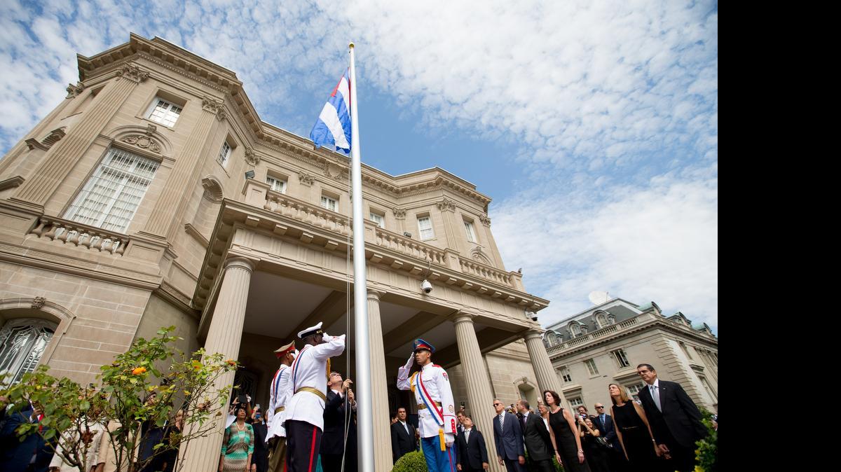 
Cuban Foreign Minister Bruno Rodriguez, center, raises the Cuban flag over its embassy in Washington on Monday, July 20, 2015. The raising of the blue, red and white-starred flag marked the start of a new post-Cold War era in U.S.-Cuba relations. 
