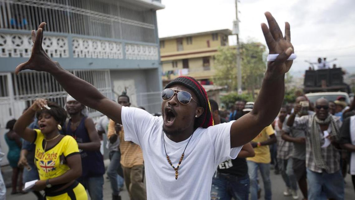 A protester chants:”Down with Martelly” during a protest against President Michel Martelly’s government in Port-au-Prince, Haiti, on Sunday. Haiti was to hold a presidential and legislative runoff election today but it was put on hold indefinitely. Sunday was also supposed to kick off pre-Carnival celebrations, but continuing protests dominated the streets instead.