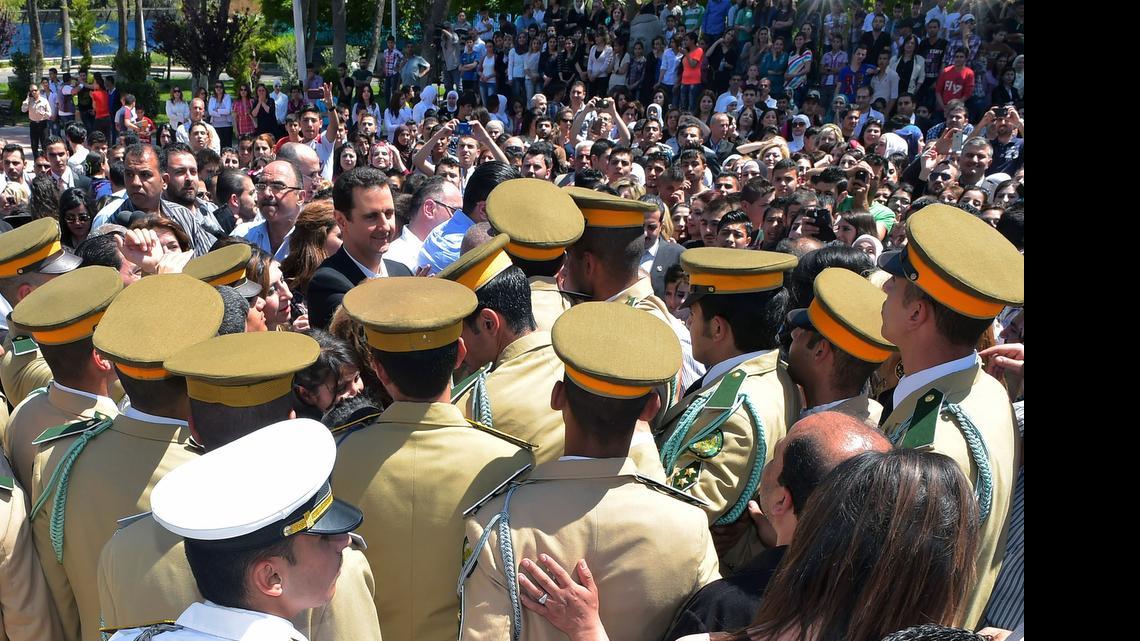 
In this photo released by the Syrian official news agency SANA, Syrian President Bashar Assad, center, waves to students during a public appearance at a school in Damascus, Syria, Wednesday, May 6, 2015. Turkey and Saudi Arabia have converged on an aggressive new strategy to bring down Syrian President Bashar Assad. 
