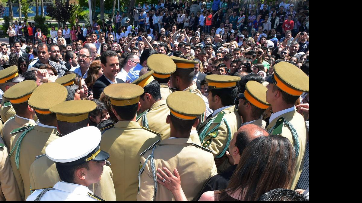 
In this photo released by the Syrian official news agency SANA, Syrian President Bashar Assad, center, waves to students during a public appearance at a school in Damascus, Syria, Wednesday, May 6, 2015. Turkey and Saudi Arabia have converged on an aggressive new strategy to bring down Syrian President Bashar Assad. 
