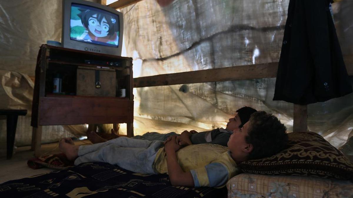 
In this Thursday, Sept. 10, 2015 photo, Syrian refugee boys watch television inside their family's tent at a Syrian refugee camp in the town of Deir Zanoun, Bekaa Valley, Lebanon. The unending misery of the around 4 million Syrian refugees scattered around Turkey, Lebanon, Jordan and other Arab nations is one significant factor in the rise of those willing to risk the dangerous sea crossing and exhausting land trek to Europe. With the Syrian civil war in its fifth year, they have little hope of returning home, and for many the situation in exile is worsening.
