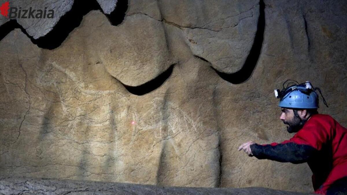 An archaeologist points toward a cave drawing on ledges 1,000 feed underground in the northern Basque region of Spain. About 70 Paleolithic-era cave drawings were discovered.