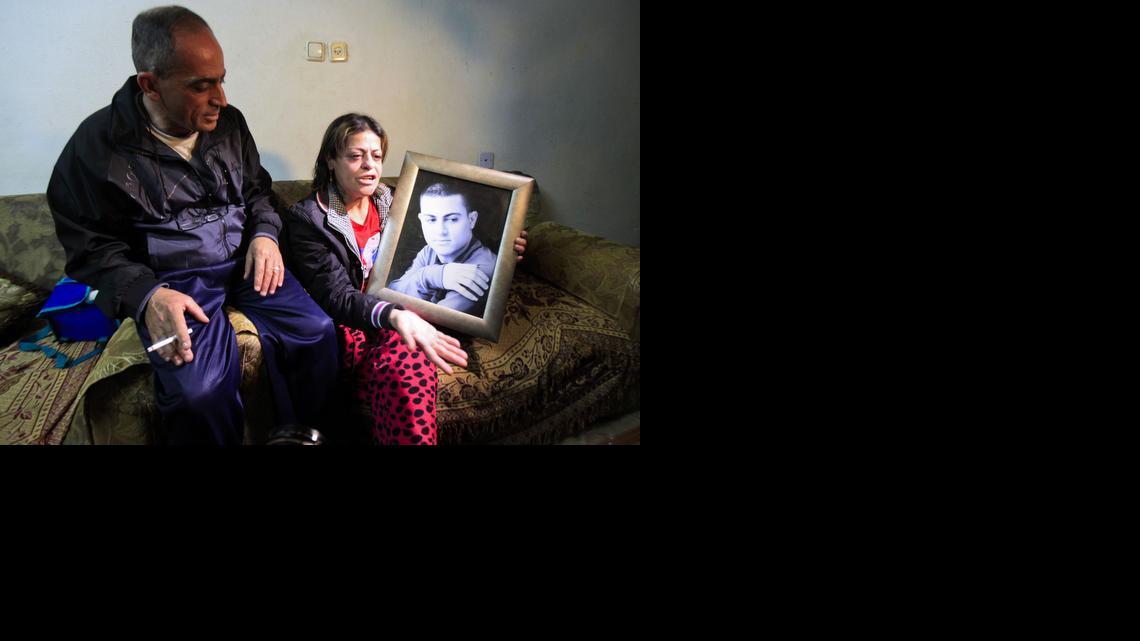
Hind, the mother of Mohamed Said Ismail , holds a picture of her son on Tuesday, March 10, 2015, while seated next to her husband Said Musalam at their home. The Islamic State group released a video Tuesday that purports to show the killing of Mohamed Said Ismail accused of being a spy for Israeli intelligence. The father of the Palestinian youth killed by the Islamic State in Syria says his son was no Israeli spy but was tricked into joining the militants. 
