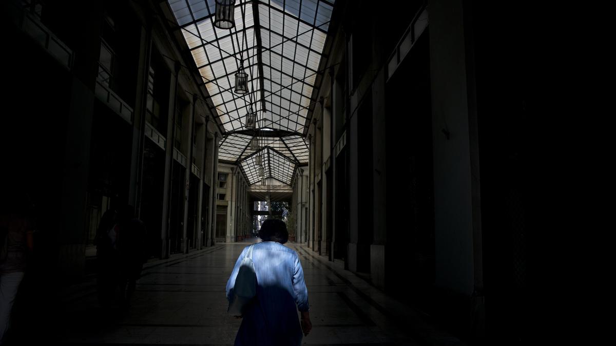 
A man passes through an arcade with shuttered shops in central Athens on Tuesday. The experts say Greece has largely failed in previous crackdowns on tax evasion, which has been rampant for generations. An estimated 10 billion euros in taxes never makes it into government coffers annually. 
