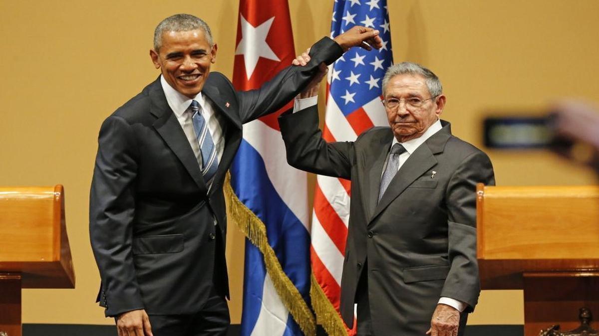Cuban leader Raul Castro lifts President Barack Obama's arm after delivering speeches at the Palacio de la Revolucion in Havana on Monday, March 21, 2016.
