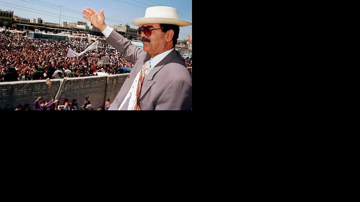 
Former Iraqi President Saddam Hussein waves to people of Saddam City during his visit April 21, 1998. 
