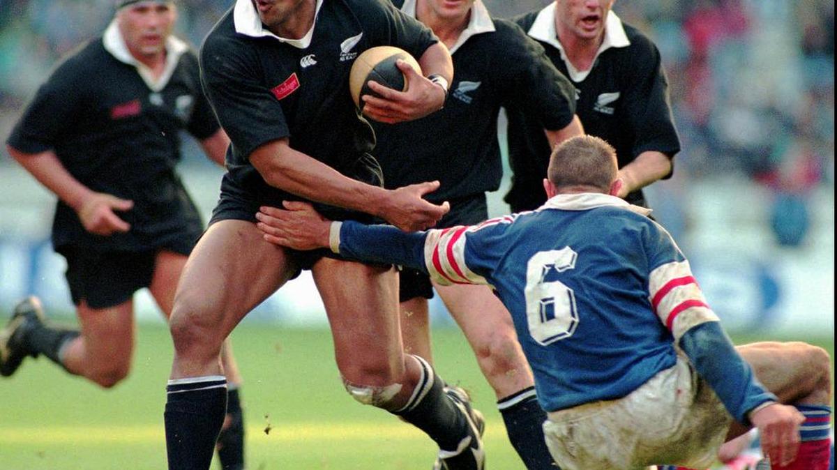 In this Saturday, Nov. 18, 1995, photo, New Zealand All Blacks winger Jonah Lomu, breaks the tackle of France's Philippe Benetton right, during their rugby test match at Parc des Princes stadium in Paris. Lomu, whose power and pace revolutionized rugby and whose humility and grace won millions of fans, died early Wednesday, Nov. 18, 2015, New Zealand Rugby said. He was 40.