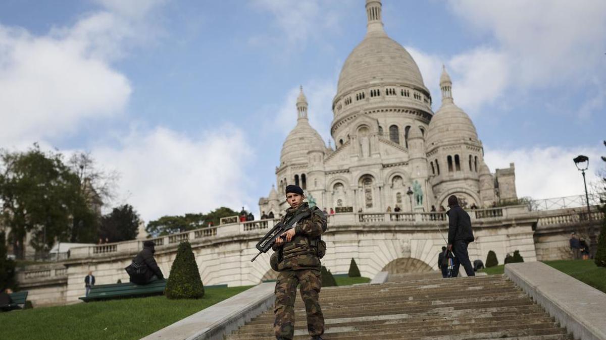 A French soldier patrols near the church of Sacre Coeur, on top of Montmartre hill, in Paris, Wednesday, Nov. 18, 2015. A woman wearing an explosive suicide vest blew herself up Wednesday as heavily armed police tried to storm a suburban Paris apartment where the suspected mastermind of last week's attacks was believed to be holed up, police said.
