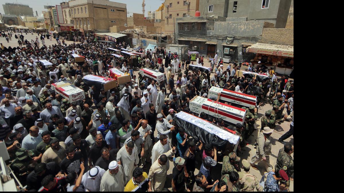
Mourners on June 8, 2015, carry the flag-draped coffins of 15 militia members of a Shiite group, Asaib Ahl al-Haq, or League of the Righteous, who were killed in Beiji, Iraq, fighting with Islamic State militants, according to their families.  
