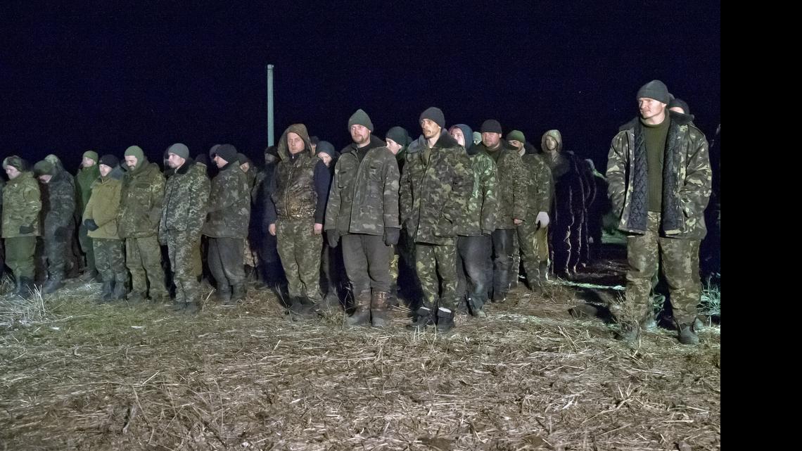 
In this Saturday Feb. 21, 2015 file photo, Ukrainian prisoners of war wait in line before a prisoner exchange in Russia-backed separatist controlled territory, near the village of Zholobok, some 20 kilometers (12 miles) west of Luhansk, Ukraine. Both warring sides in eastern Ukraine are perpetrating war crimes almost daily, including torturing prisoners and summarily killing them, the Amnesty International rights group said in a report Friday May 22, 2015. 
