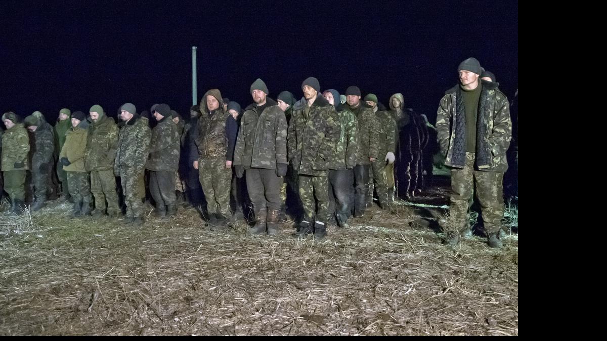 
In this Saturday Feb. 21, 2015 file photo, Ukrainian prisoners of war wait in line before a prisoner exchange in Russia-backed separatist controlled territory, near the village of Zholobok, some 20 kilometers (12 miles) west of Luhansk, Ukraine. Both warring sides in eastern Ukraine are perpetrating war crimes almost daily, including torturing prisoners and summarily killing them, the Amnesty International rights group said in a report Friday May 22, 2015. 
