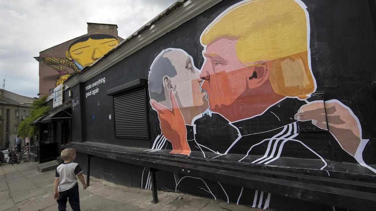 A child walks past a graffiti depicting Russian President Vladimir Putin, left, and Republican presidential candidate Donald Trump, on the walls of a bar in the old town in Vilnius, Lithuania, Saturday, May 14, 2016.