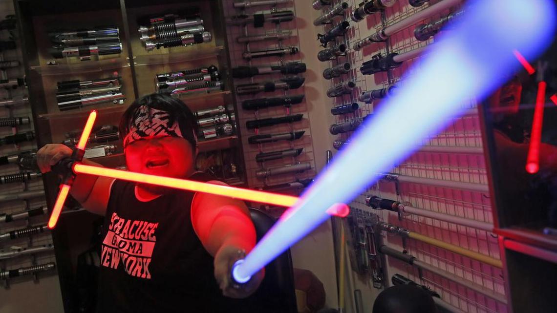 In this Dec. 14, 2015, photo, 32-year-old Tsai Jung-chou, also known as “Makoto Tsai”, poses with his handcrafted replicas of the Star Wars lightsaber at his home workshop in New Taipei City, Taiwan. A former optical engineer, Tsai now designs and fabricates his own versions of the iconic sci-fi weapon which he sells for up to $400 per model.
