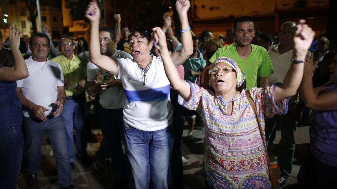Opposition supporters celebrates the closing of a polling station during congressional elections in Caracas, Venezuela, on Sunday. Some members of the opposition are angry after elections officials ordered polling centers to stay open for an extra hour, even if no one was standing in line to vote. Government opponents mobbed some voting stations demanding that the National Guard stick to the original schedule of closing at 6 p.m.