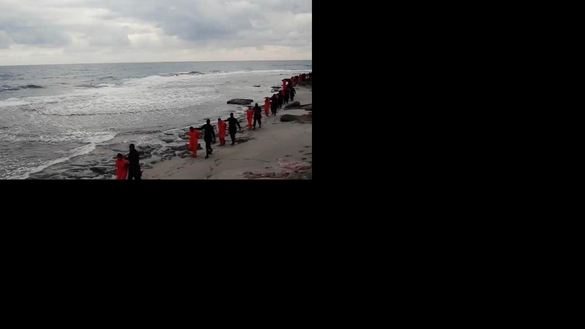
In this file image made from a video released Sunday, Feb. 15, 2015 by militants in Libya claiming loyalty to the Islamic State group purportedly shows Egyptian Coptic Christians in orange jumpsuits being led along a beach, each accompanied by a masked militant. 
