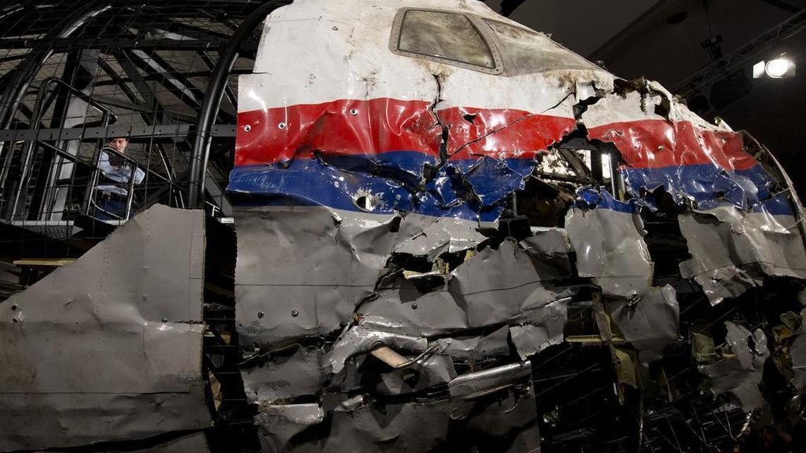 
A Dutch Military Policeman, left inside, guards part of the reconstructed cockpit, right, and forward section of the fuselage after the Dutch Safety Board presented its final report into what caused Malaysia Airlines Flight 17 to break up high over Eastern Ukraine last year, killing all 298 people on board, during a press conference in Gilze-Rijen, central Netherlands, Tuesday, Oct. 13, 2015. 
