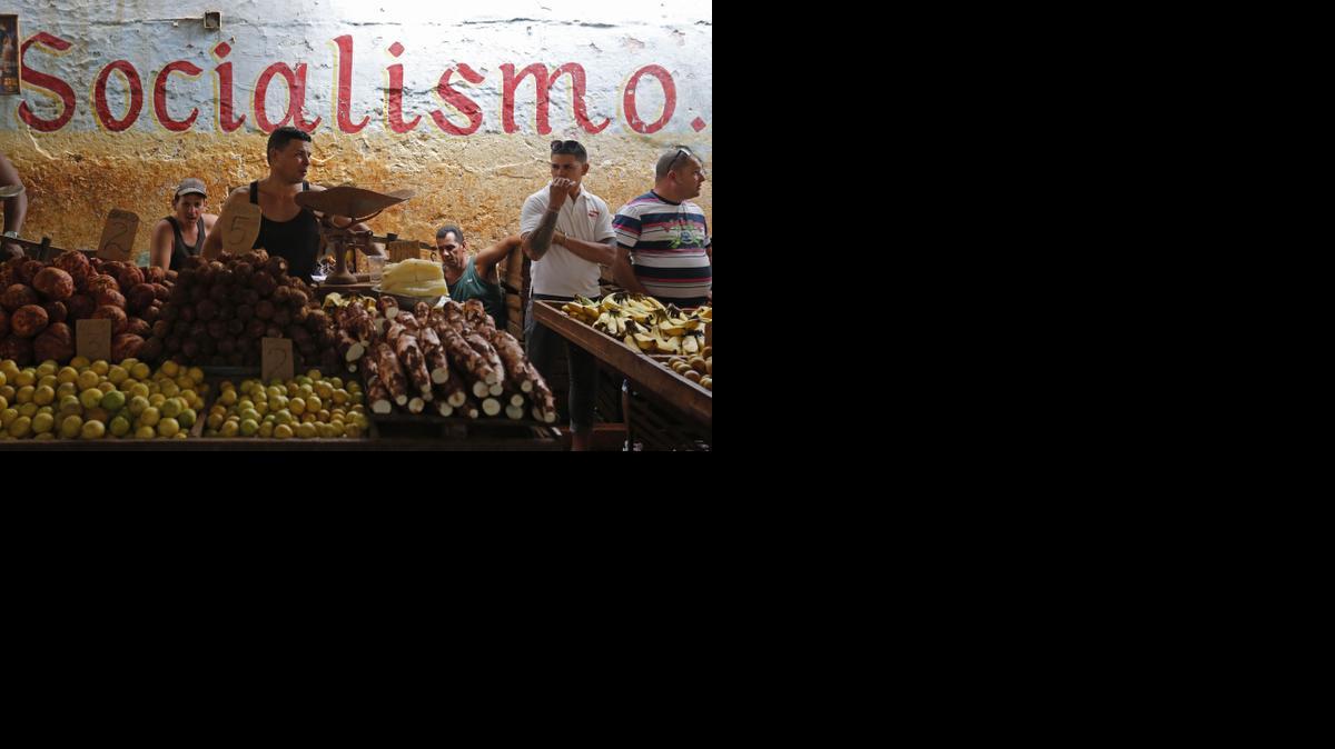 
Workers stand behind their food stalls at a state-run market in Havana, Cuba, Saturday, Dec. 20, 2014. 

