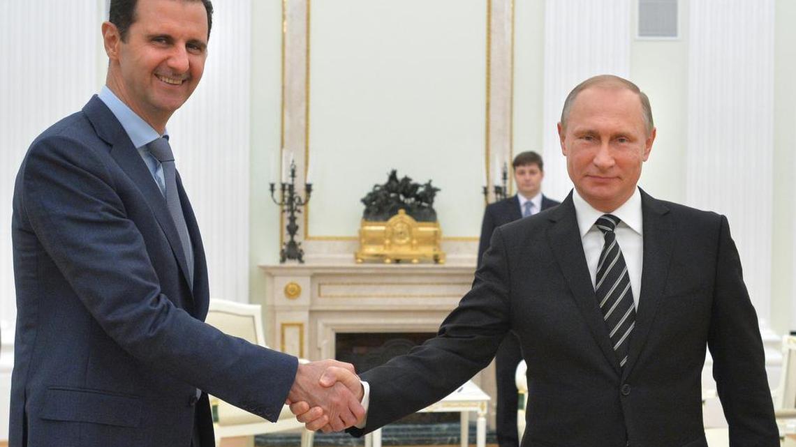 In this photo taken on Tuesday, Oct. 20, 2015, Russian President Vladimir Putin, right, shakes hand with Syria President Bashar Assad in the Kremlin in Moscow, Russia. Assad has traveled to Moscow in his first known trip abroad since the war broke out in Syria in 2011 to meet his strongest ally Russian leader Vladimir Putin, Syrian and Russian media reported Wednesday.