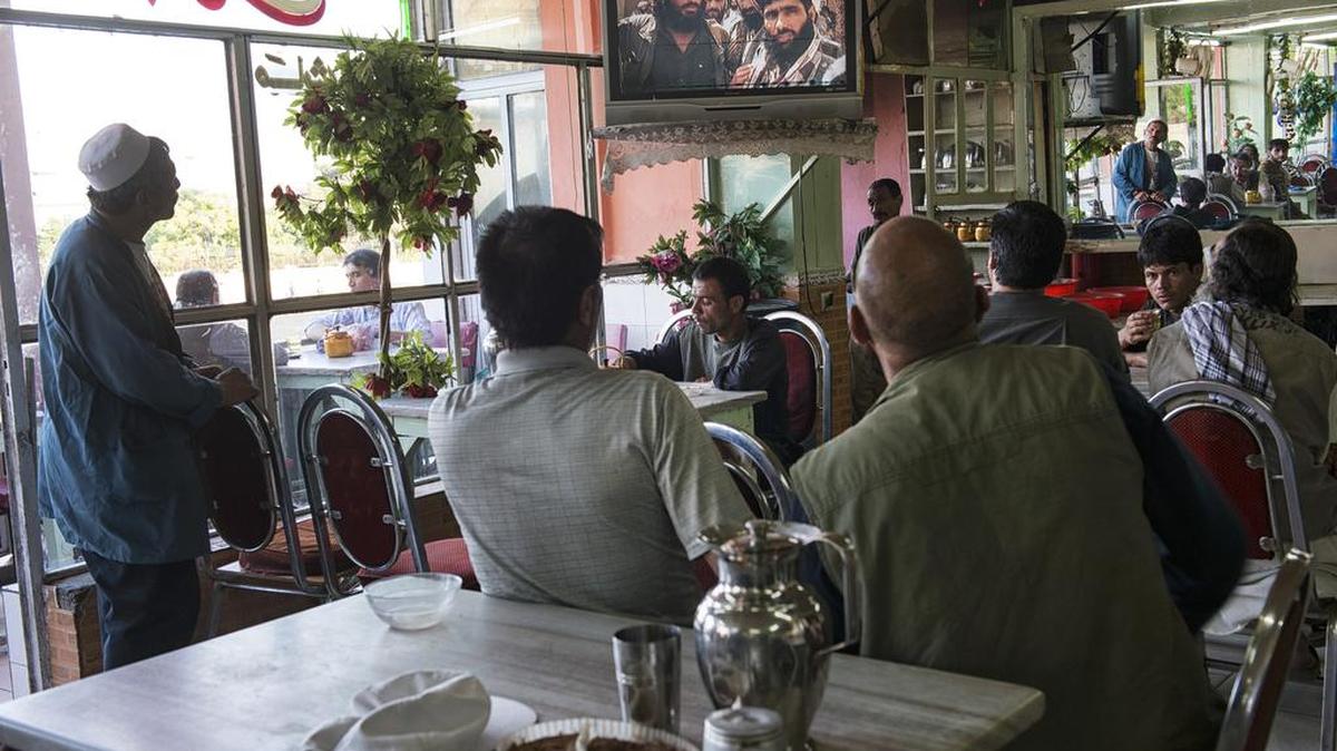 Afghans watch news coverage about peace talks between the Taliban and the Afghan government, at a cafe in Kabul in June 2013. Reports that the Afghan Taliban’s new leader, Akhtar Mohammad Mansour, has been shot in Pakistan in an internal dispute could complicate future peace talks.