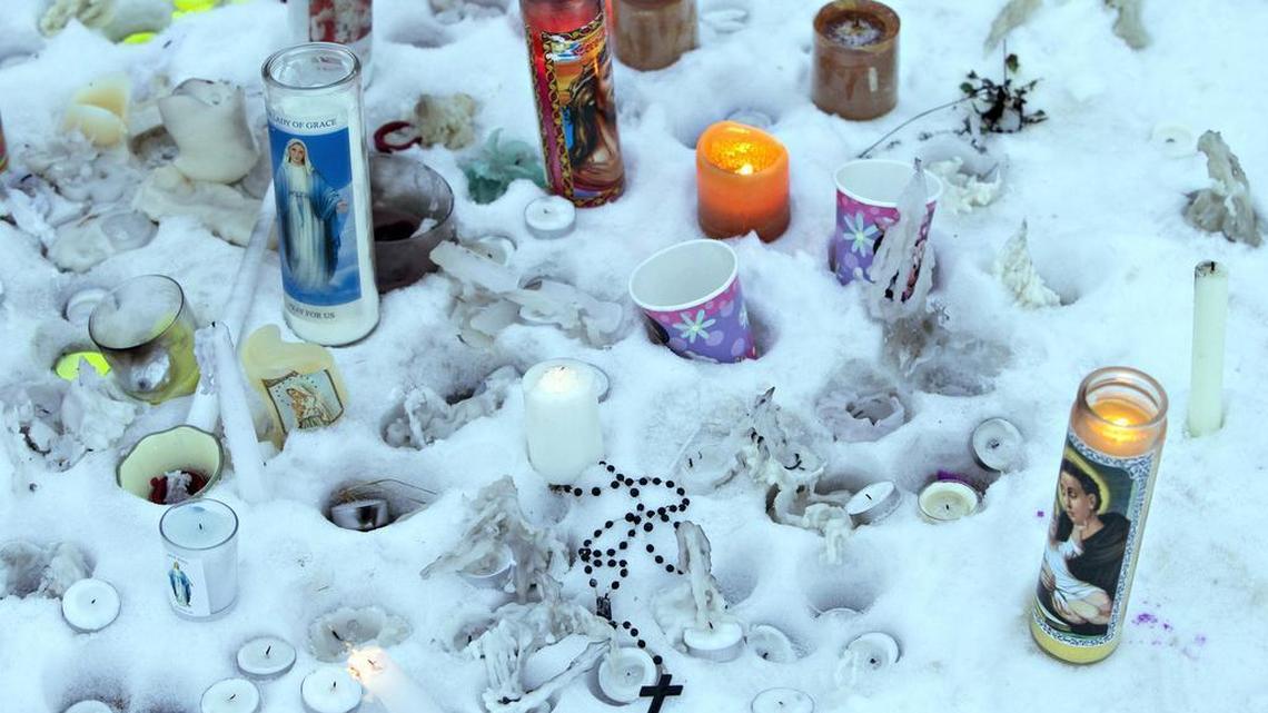 Candles and flowers mark a makeshift memorial near the La Loche, Saskatchewan, junior and senior high school on Saturday, Jan. 23, 2016.