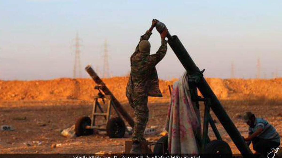 
In this image posted on Thursday, Oct. 8, 2015, by the Rased News Network, a Facebook page affiliated with Islamic State, shows Islamic State militants preparing to fire a mortar to shell towards Syrian government forces positions at Tal Arn in Aleppo province, Syria. Islamic State militants seized several villages from rival insurgents north of Aleppo city Friday, in a surprise attack that came despite intensive Russian airstrikes that Moscow insists are targeting the extremist group, activists said. Arabic reads, "Targeting positions of the Alawite army in Tal Arn with mortar shells."
