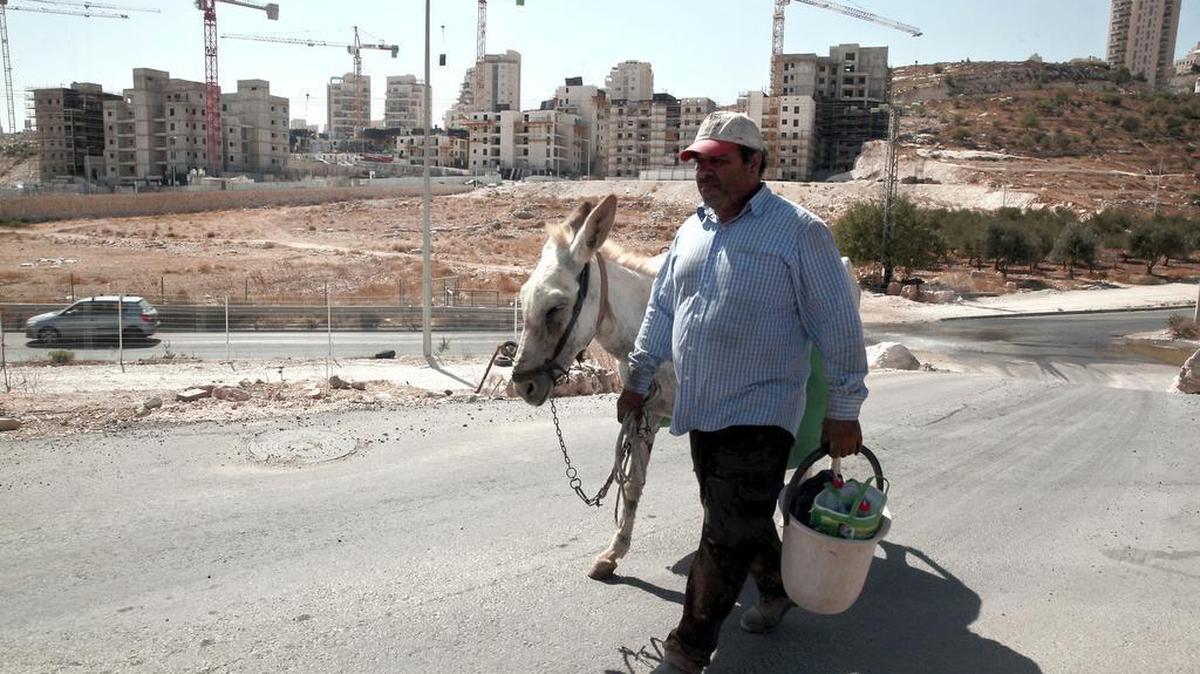 In this Sept. 20, 2016 file photo, a Palestinian man walks near a construction site of a new housing unit in the east Jerusalem neighborhood of Har Homa.