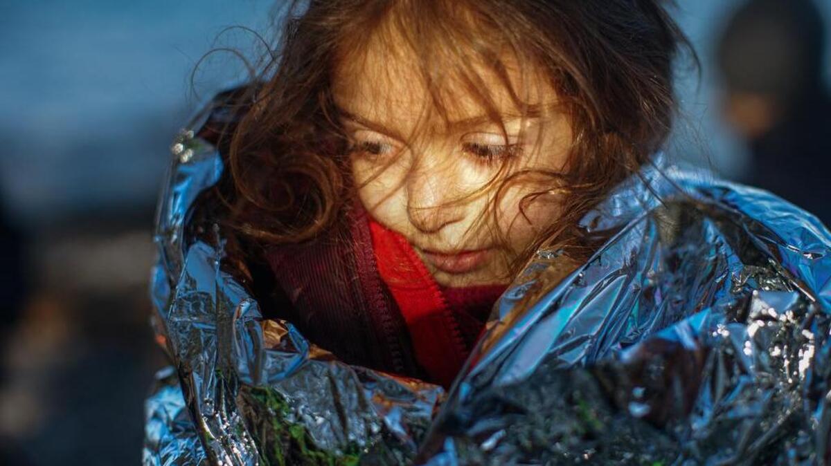 A migrant girl tries to warm herself as she disembarks a boat at Lesbos Island, Greece, on Monday. More than 850,000 people, most fleeing conflict in Syria and Afghanistan, entered Greece by sea in 2015, according to the UNHCR, and already in 2016, some 35,455 people have arrived despite plunging winter temperatures.