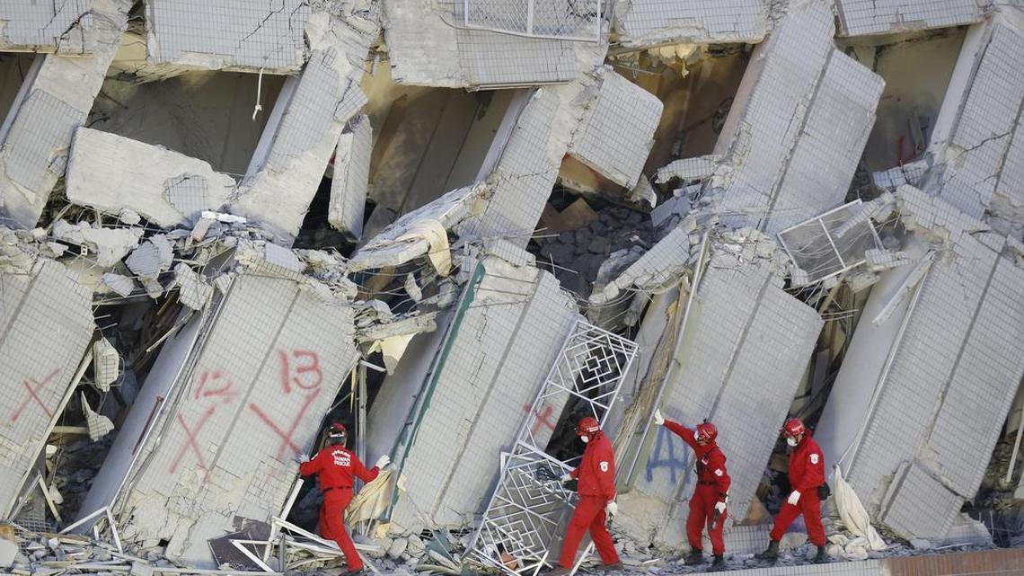 Emergency rescuers continue to search for the missing in a collapsed building from an earthquake in Tainan, Taiwan, Sunday, Feb. 7, 2016. Rescuers on Sunday found signs of life within the remains of the residential high-rise.