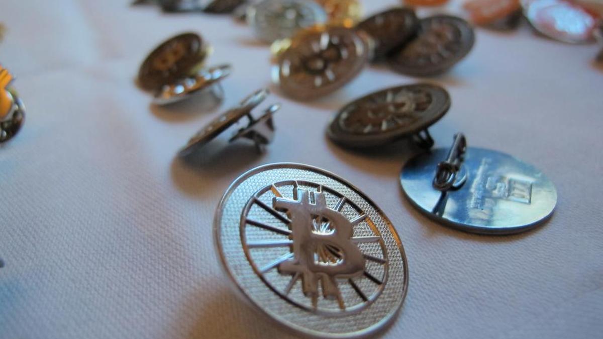Bitcoin buttons are displayed on a table at the Inside Bitcoins conference in Berlin on Wednesday, Feb. 12, 2014.