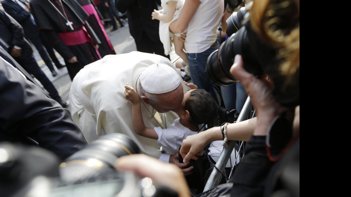 
Pope Francis kisses a child during a meeting with young people, in Turin, Italy, Sunday, June 21, 2015. Pope Francis earlier prayed in front of the Holy Shroud, the 14 foot-long linen revered by some as the burial cloth of Jesus, on display at the Cathedral of Turin. 
