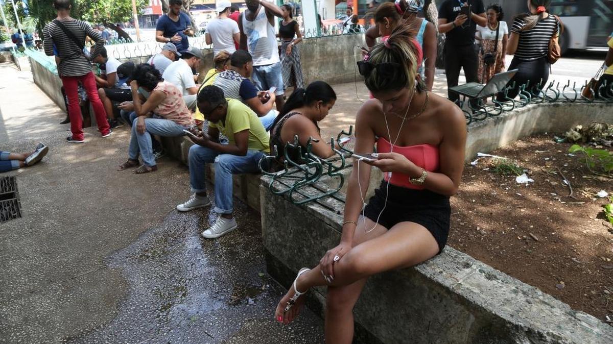 Dozens of Cubans log on to public Wi-Fi along a stretch of road in the Vedado district of Havana known as La Rampa, or the Ramp.
