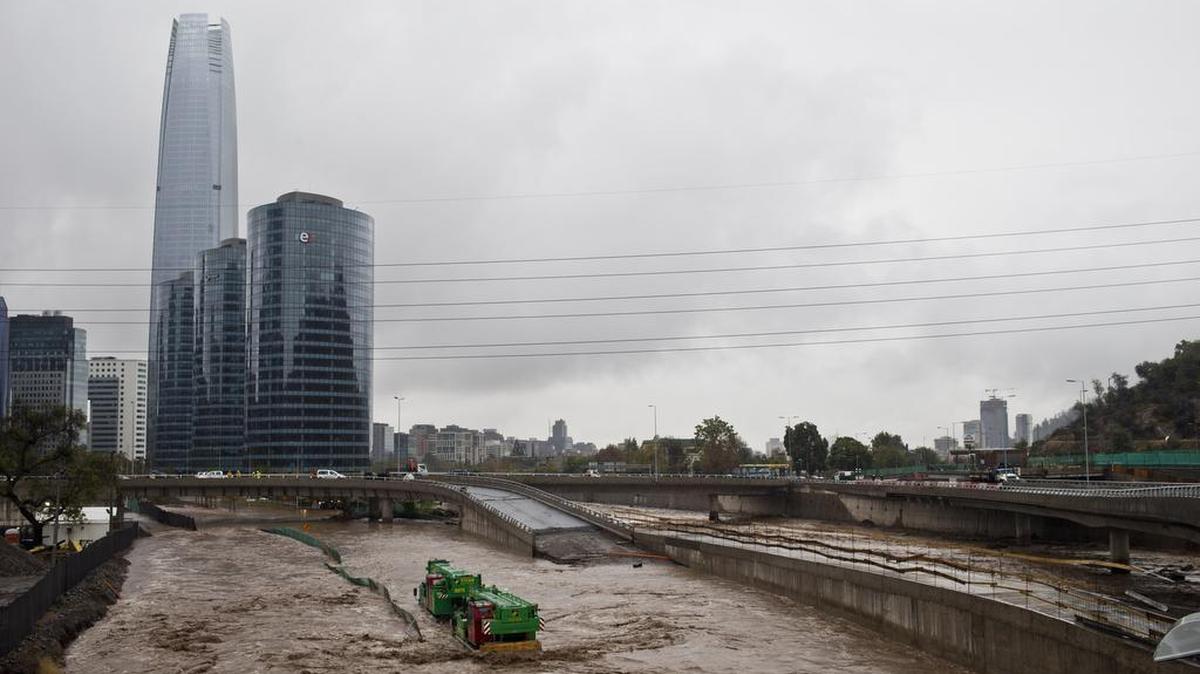 A crane is caught in the middle of a flooded street in Santiago, Chile, on Sunday. Authorities say the Rio Mapocho flooded several districts of the city and landslides killed at least one person.