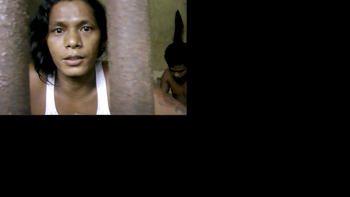 
In this Thursday, Nov. 27, 2014, image from video, Kyaw Naing, a slave from Myanmar, looks through the bars of a cell at the compound of a fishing company in Benjina, Indonesia. After working for three years on a Thai trawler, sometimes enduring beatings with the bones of sting ray, he begged his captain to let him return home. "All I did was tell my captain I couldn't take it anymore, that I wanted to go home," Naing says. "The next time we docked, I was locked up." 

