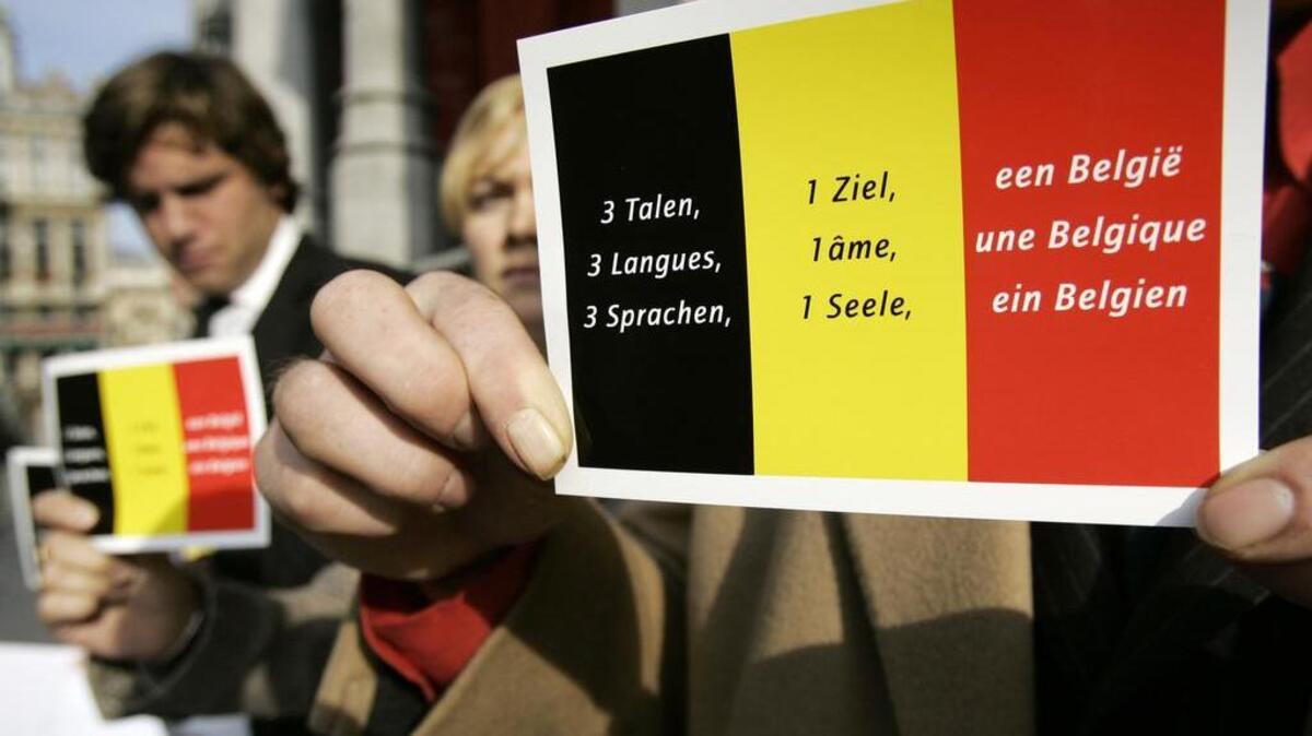 Pro-Belgian supporters show a sticker with the Belgian national flag and a text that reads in the country’s three official languages, Dutch, French and German, “Three languages, One soul, One Belgium,” during a Sept. 27, 2015, demonstration in Brussels. Many of the weaknesses in fighting extremism have been linked to Belgium’s complicated linguistic divide.