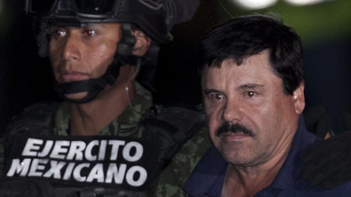 Mexican drug lord Joaquin "El Chapo" Guzman, right, is escorted by soldiers and marines to a waiting helicopter, at a federal hangar in Mexico City, Friday, Jan. 8, 2016. The world's most wanted drug lord was recaptured by Mexican marines Friday, six months after he fled through a tunnel from a maximum security prison in an escape that deeply embarrassed the government and strained ties with the United States.