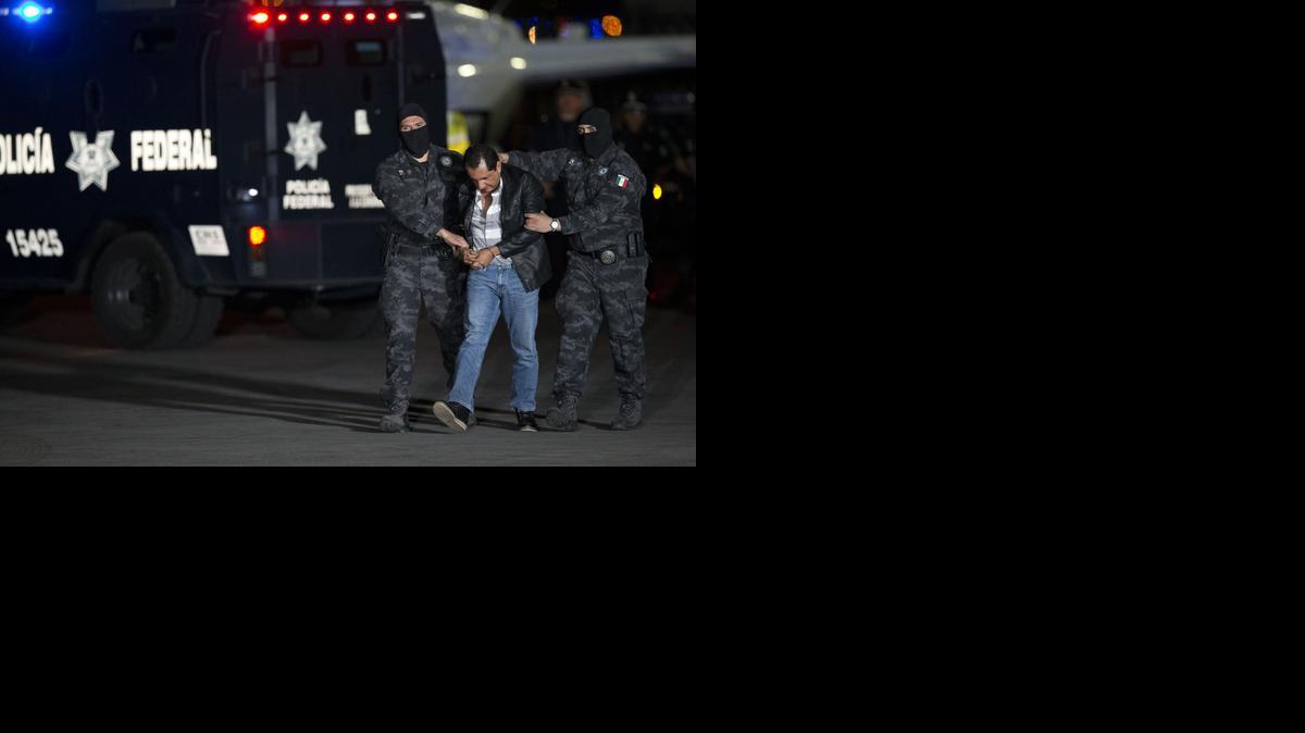 
Flavio Gomez, identified by police as the brother of Servando "La Tuta" Gomez, the head of the Knights Templar drug cartel, is escorted to a federal police truck at the airport in Mexico City, Friday, Feb. 27, 2015. Servando Gomez, a former school teacher who became one of Mexico's most-wanted drug lords, was captured early Friday by federal police in Morelia, the capital of the western state of Michoacan.
