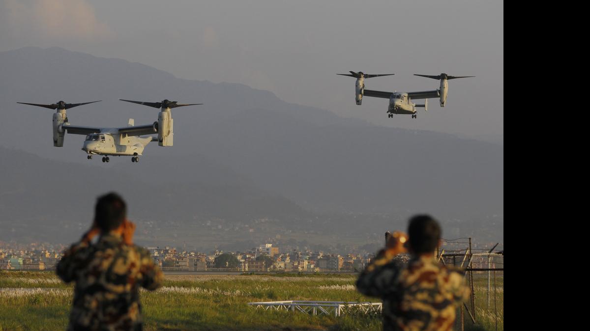 
Nepalese soldiers take pictures as US Air Force Bell Boeing V-22 Osprey aircrafts arrive at the Tribhuvan International airport in Kathmandu, Nepal, Sunday, May 3, 2015. Runway damage forced Nepalese authorities to close the main airport Sunday to large aircraft delivering aid to millions of people following the massive earthquake, but U.N. officials said the overall logistics situation was improving. 
