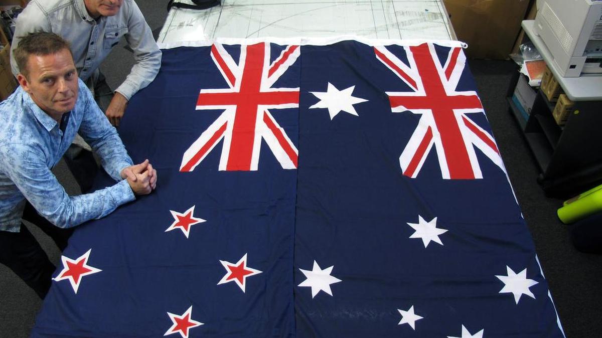 
Victor Gizzi, left, and David Moginie, managers at flag manufacturer Flagmakers, pose next to flags of New Zealand, left, and Australia, in their factory near Wellington, New Zealand, in 2014. 
