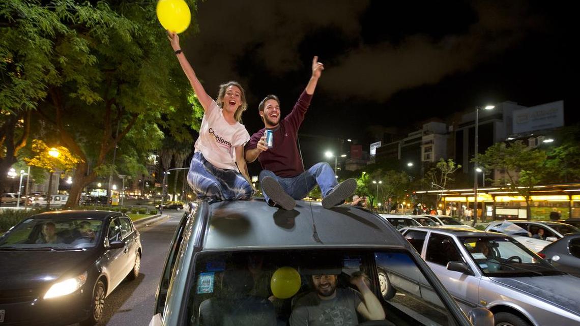 Supporters of presidential candidate Mauricio Macri ride on top of a car towards the Obelisk plaza to celebrate in Buenos Aires on Sunday. Macri won Argentina's historic runoff election against ruling party candidate Daniel Scioli, putting an end to the era of President Cristina Fernandez, who along with her late husband dominated Argentine politics for 12 years.