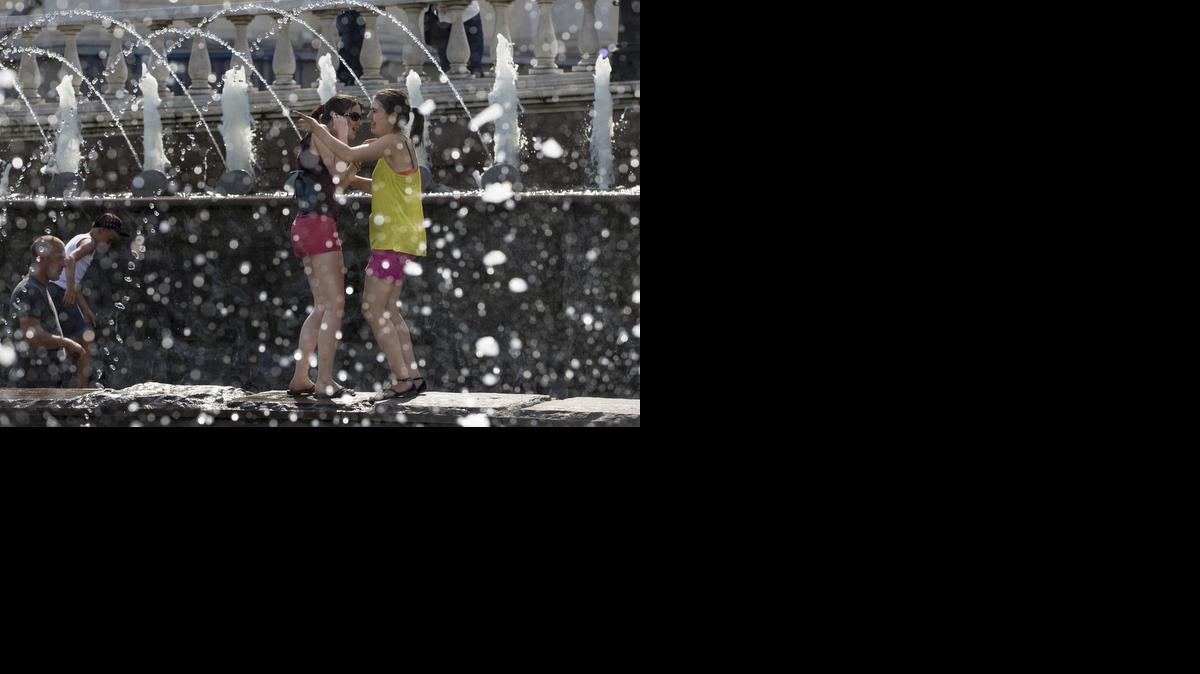 
In this July 30, 2014 file photo, girls cool themselves in a fountain after a sunny and hot day in Alexandrov Garden at the Kremlin Wall in Moscow, Russia. Federal science officials announced Friday that for the third time in a decade, the globe sizzled to the hottest year on record. 
