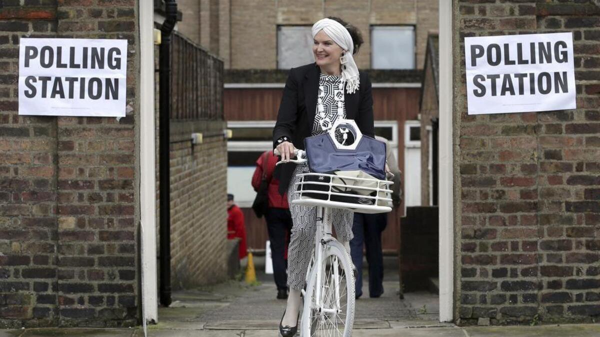 A woman on a bicycle leaves a polling station near to the Royal Chelsea Hospital, London on Thursday. Voters in Britain are deciding Thursday whether the country should remain in the European Union.