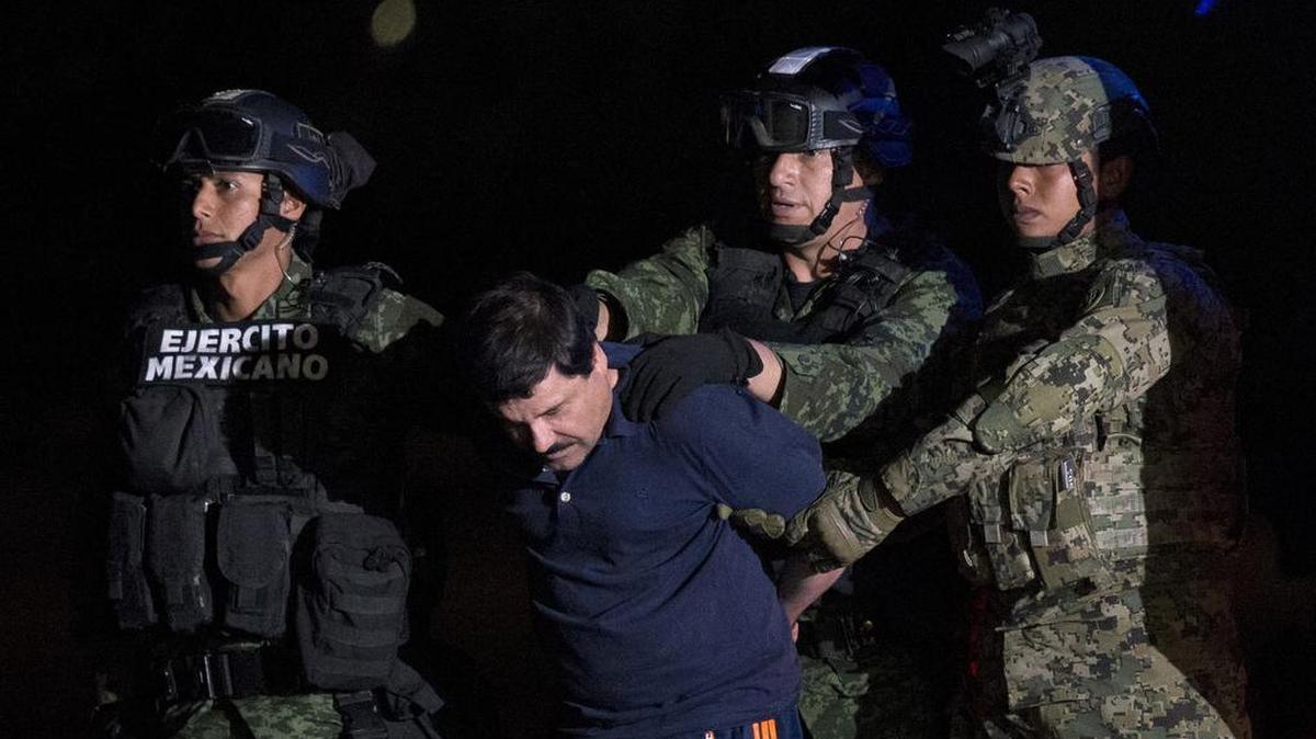 Mexican drug lord Joaquin “El Chapo” Guzman is escorted by army soldiers to a waiting helicopter, at a federal hangar in Mexico City, Friday, Jan. 8, 2016. The world’s most wanted drug lord was recaptured by Mexican marines Friday, six months after he fled through a tunnel from a maximum secuirty prison in a made-for-Hollywood escape that deeply embarrassed the government and strained ties with the United States. (AP Photo/Rebecca Blackwell)