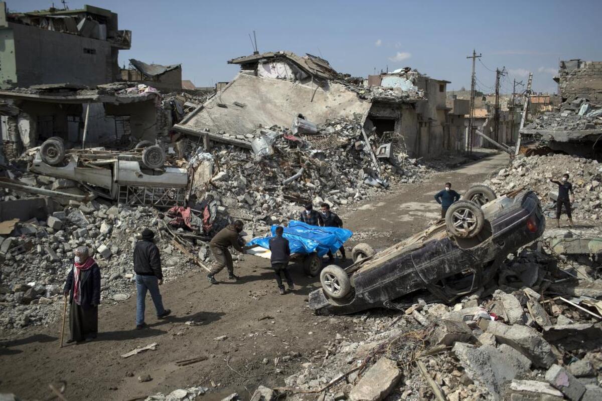 Residents carry the body of several people killed during fights between Iraq security forces and Islamic State on the western side of Mosul, Iraq, Friday, March 24, 2017.