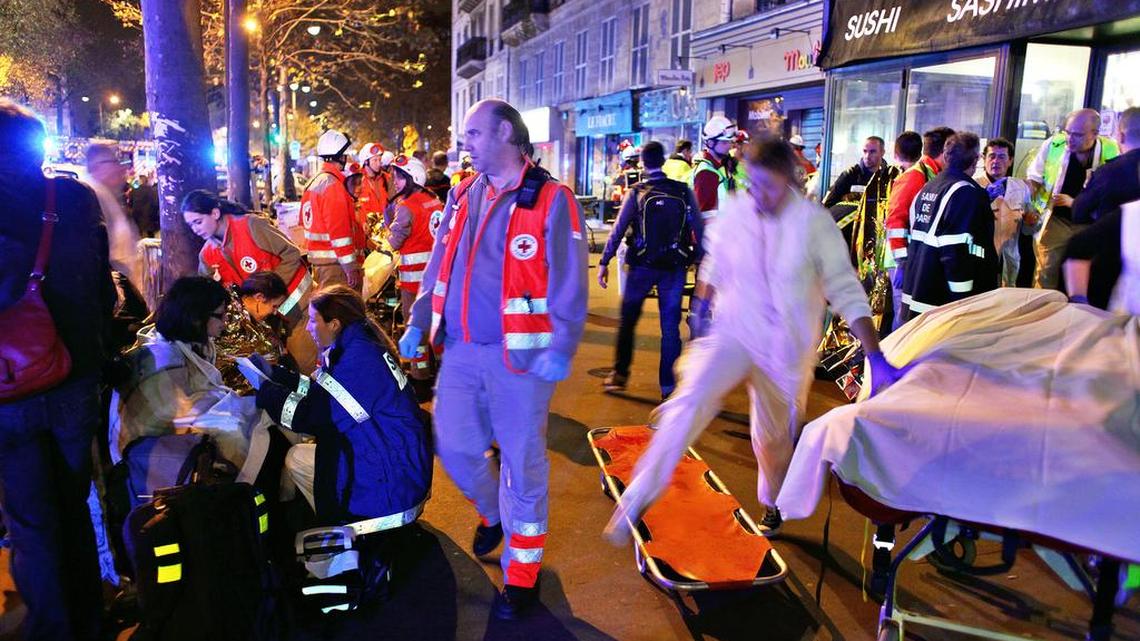 People rest on a bench after being evacuated from the Bataclan theater after a shooting in Paris, Nov. 14, 2015. A series of attacks targeting young concert-goers, soccer fans and Parisians enjoying a Friday night out at popular nightspots killed more than 100 people in the deadliest violence to strike France since World War II.