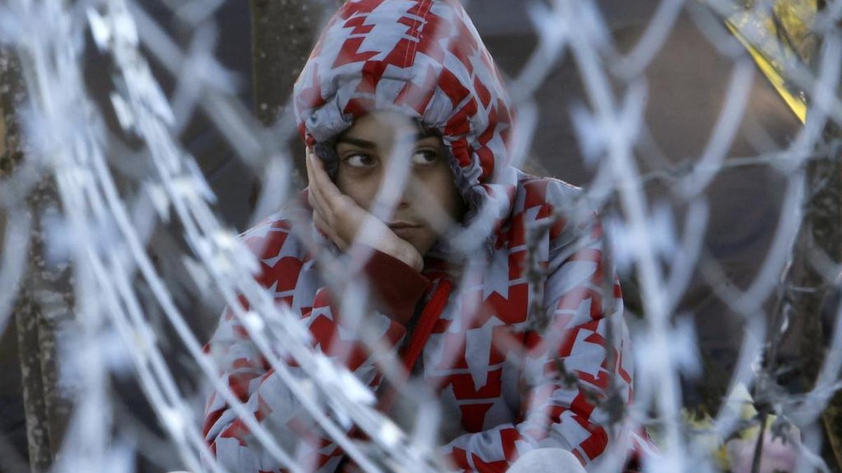 Erfan, an Iranian migrant, sits behind a fence while waiting with his family at the Greek-Macedonian border, after being denied to enter in Macedonia, near the southern Macedonian town of Gevgelija, on Sunday. Macedonia has started to erect a fence on its southern border with neighboring Greece in order to prevent illegal crossings and to channel the flow of migrants through the official checkpoint, where only migrants from the war-affected zones will be allowed to enter.